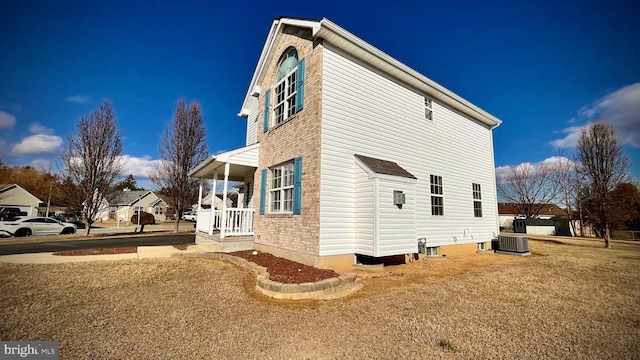 view of side of property with central AC and a lawn