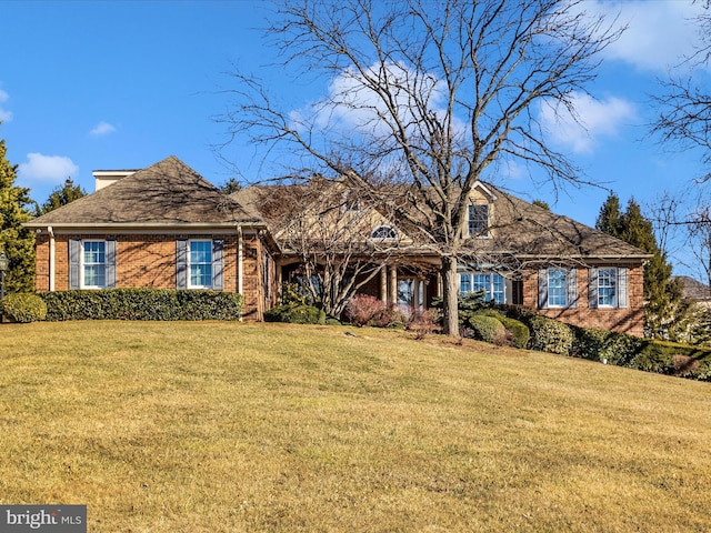 view of front of property with a front lawn and brick siding