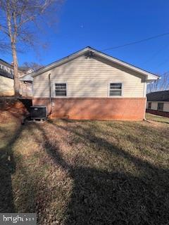 view of side of property with cooling unit and a lawn