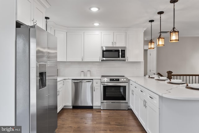 kitchen featuring pendant lighting, dark wood-type flooring, white cabinetry, stainless steel appliances, and kitchen peninsula