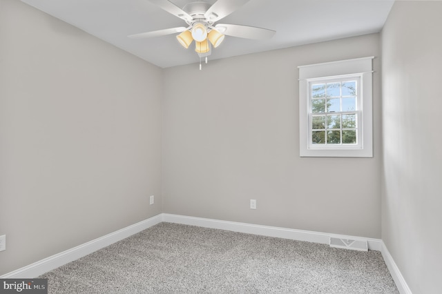 unfurnished room with ceiling fan and carpet