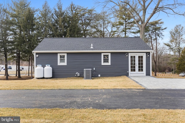 back of property featuring french doors, a yard, and cooling unit