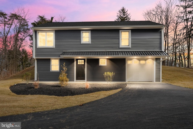 view of front of house featuring a garage and a lawn