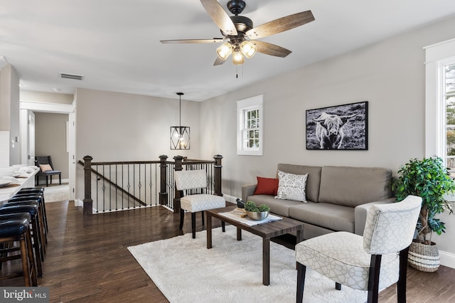 living room with dark wood-type flooring and ceiling fan