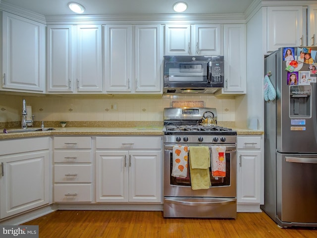 kitchen featuring white cabinetry, appliances with stainless steel finishes, sink, and light wood-type flooring