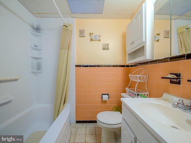 full bathroom featuring shower / tub combo with curtain, tile walls, vanity, toilet, and tile patterned floors