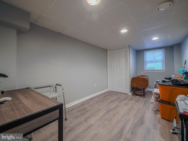 office space featuring a paneled ceiling and light hardwood / wood-style flooring