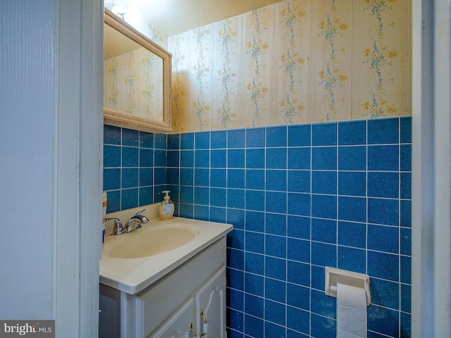 bathroom with vanity and tile walls