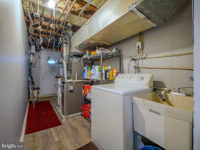 laundry room featuring hardwood / wood-style flooring, washer / clothes dryer, and sink