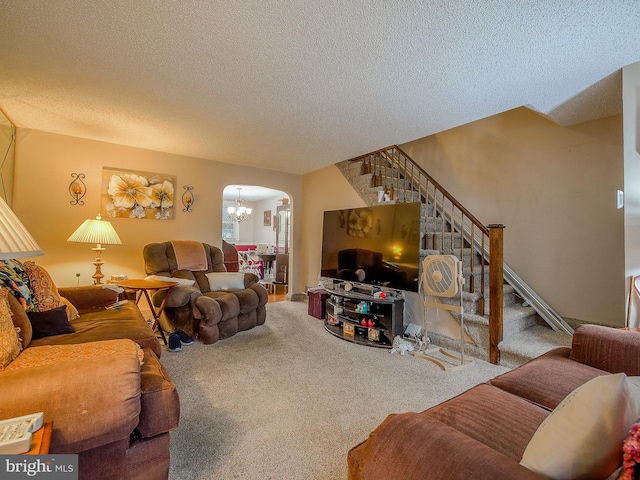 living room featuring a notable chandelier, a textured ceiling, and carpet