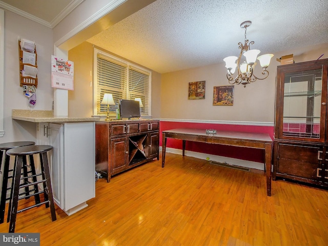 playroom featuring crown molding, an inviting chandelier, light hardwood / wood-style floors, and a textured ceiling