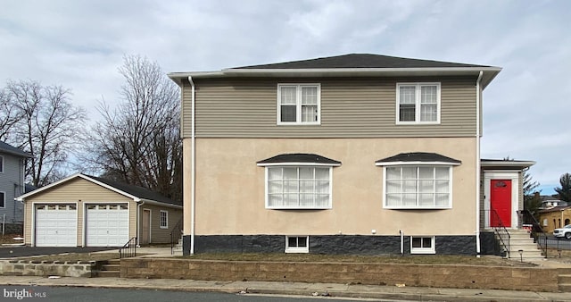 view of front of property with an outbuilding, stucco siding, a detached garage, and entry steps