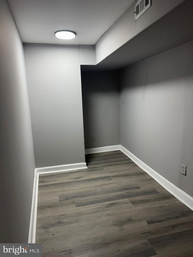 walk in closet with dark hardwood / wood-style flooring