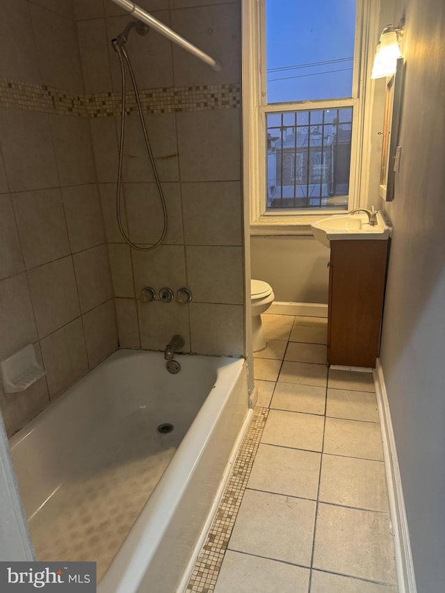 full bathroom featuring vanity, tiled shower / bath, tile patterned floors, and toilet