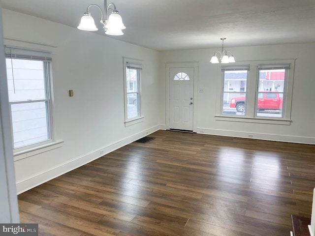 foyer entrance featuring dark hardwood / wood-style flooring and a notable chandelier