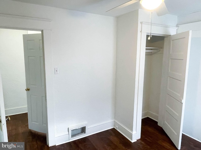 interior space with dark wood-type flooring and a closet