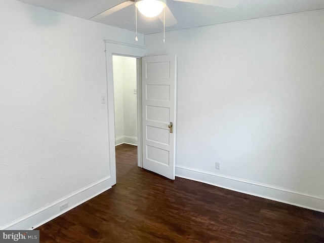 empty room featuring dark wood-type flooring and ceiling fan