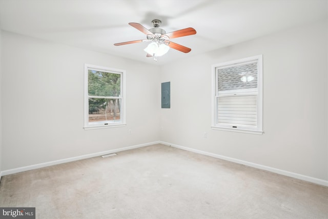 spare room with electric panel, ceiling fan, and carpet