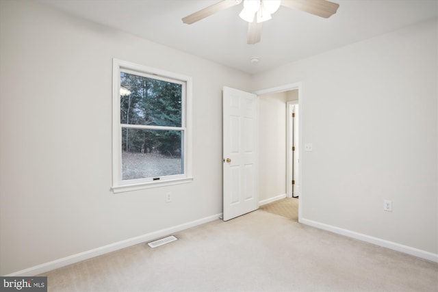 carpeted empty room with ceiling fan and a healthy amount of sunlight