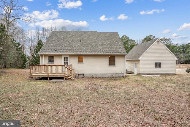 rear view of property featuring a wooden deck and a lawn