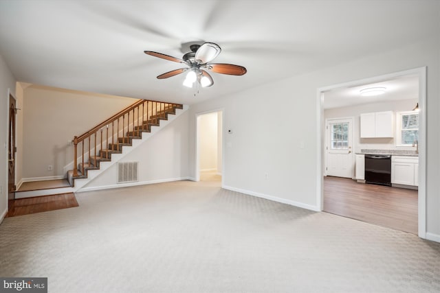 unfurnished living room featuring ceiling fan and carpet