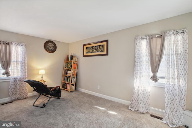 living area featuring light carpet