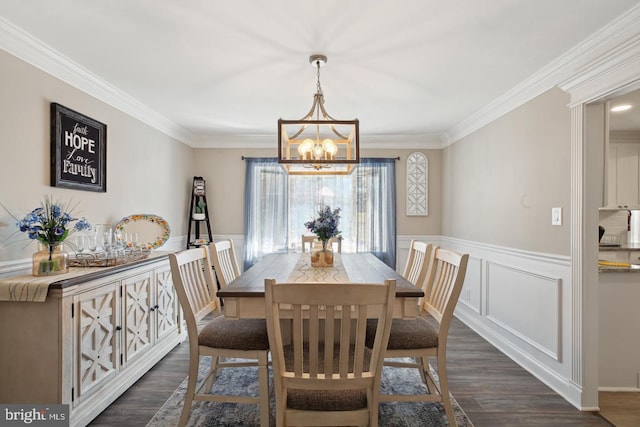 dining area featuring ornamental molding, dark wood-type flooring, and a notable chandelier