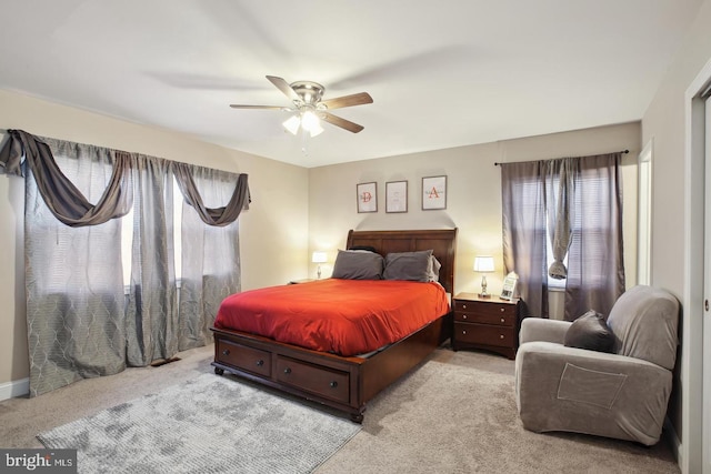 carpeted bedroom featuring ceiling fan and multiple windows