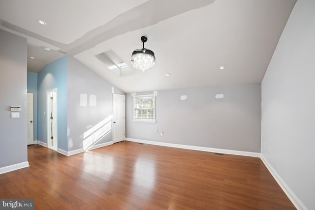 additional living space featuring an inviting chandelier, lofted ceiling, and wood-type flooring