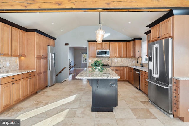 kitchen featuring a kitchen island, appliances with stainless steel finishes, decorative light fixtures, sink, and light stone counters