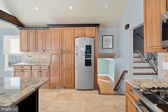 kitchen with light stone counters, light tile patterned floors, decorative backsplash, and stainless steel fridge