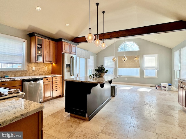 kitchen with pendant lighting, appliances with stainless steel finishes, a kitchen bar, and light stone countertops