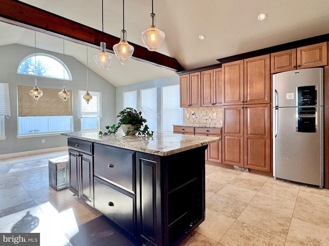 kitchen with vaulted ceiling with beams, a center island, light stone counters, and stainless steel refrigerator