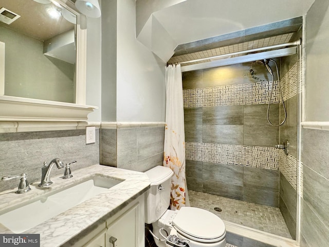 bathroom with vanity, a shower with shower curtain, tile walls, and toilet