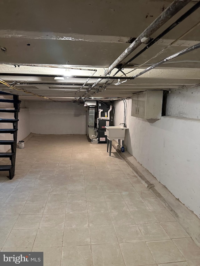 basement featuring heating unit and sink