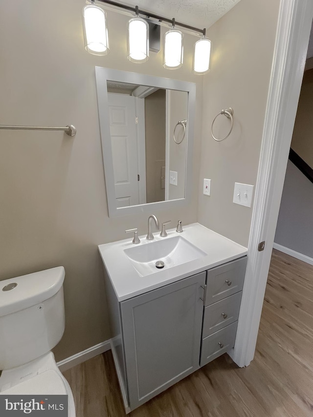 bathroom featuring vanity, hardwood / wood-style floors, and toilet