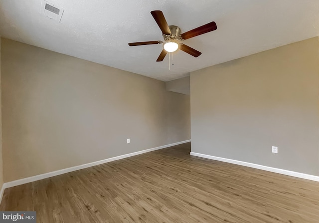 empty room featuring a textured ceiling, ceiling fan, and light wood-type flooring