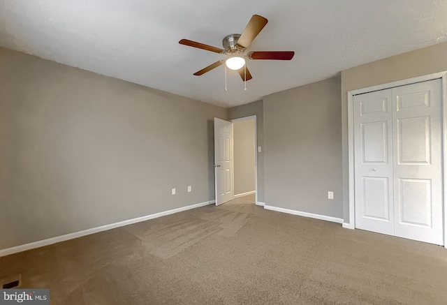 unfurnished bedroom with carpet floors, ceiling fan, and a closet