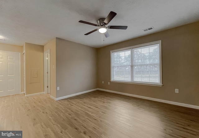 unfurnished room featuring ceiling fan, light hardwood / wood-style flooring, and a textured ceiling