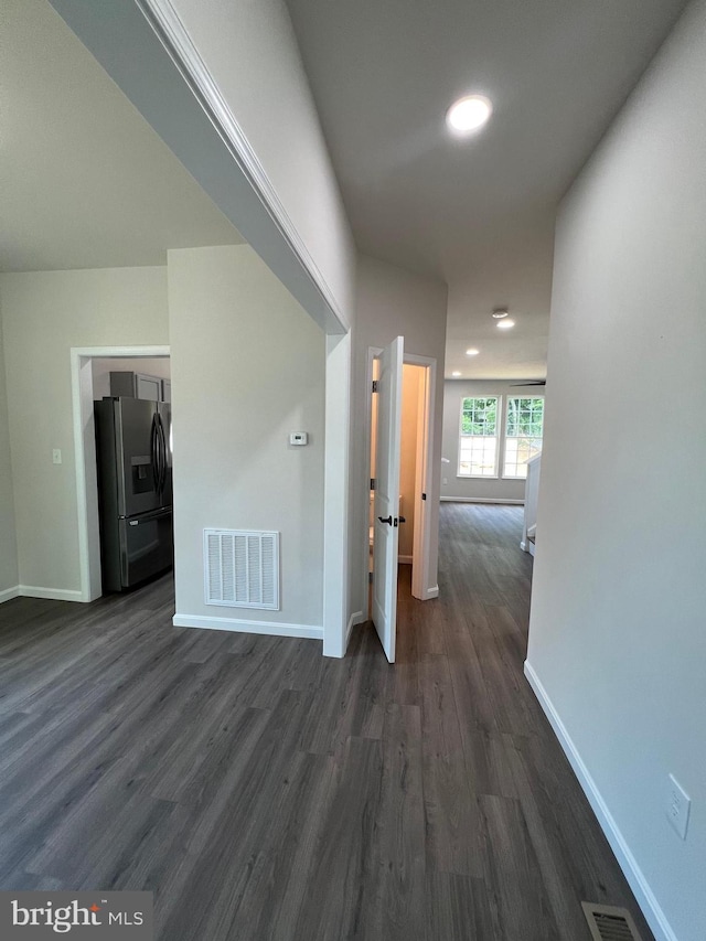 corridor with dark wood-style floors, baseboards, visible vents, and recessed lighting