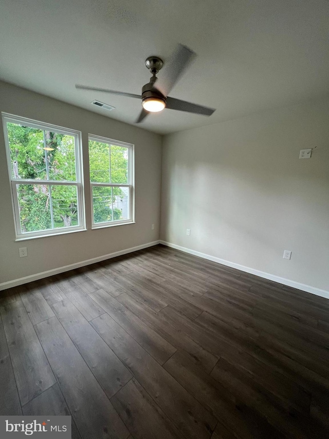 empty room featuring dark wood-type flooring and ceiling fan