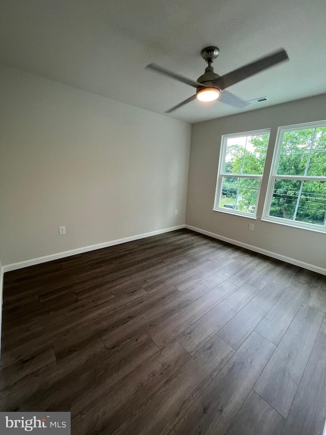 spare room with dark hardwood / wood-style floors and ceiling fan