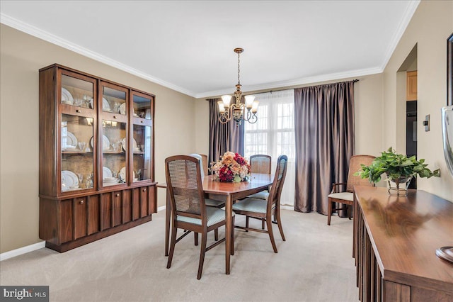 carpeted dining space with ornamental molding and a chandelier