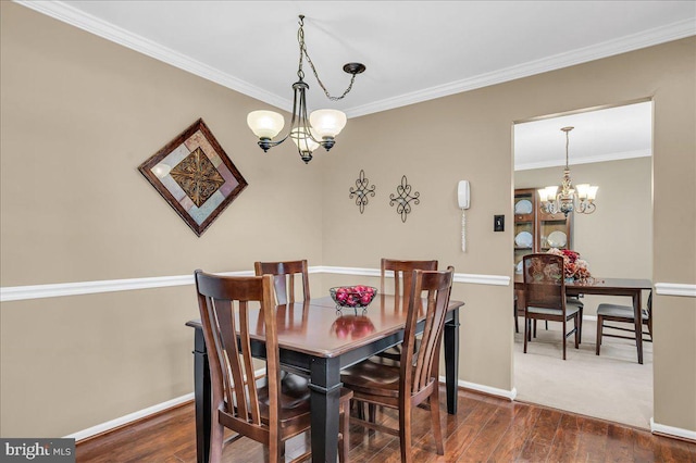 dining room with an inviting chandelier, crown molding, and dark wood-type flooring