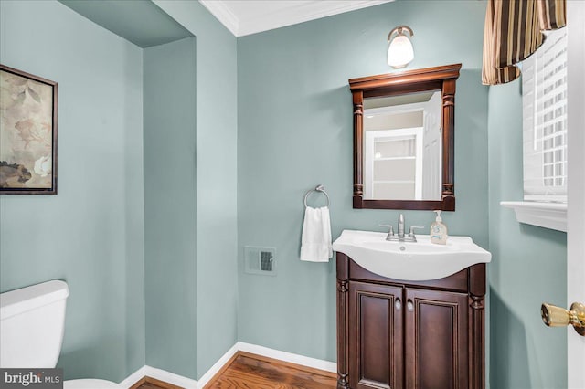 bathroom with hardwood / wood-style flooring, vanity, crown molding, and toilet