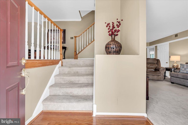 stairway with hardwood / wood-style flooring and crown molding