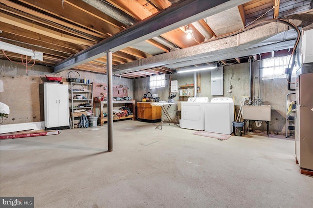 basement featuring sink, washing machine and dryer, and electric panel