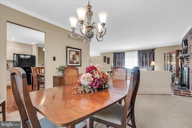 dining room with light colored carpet, ornamental molding, and a notable chandelier