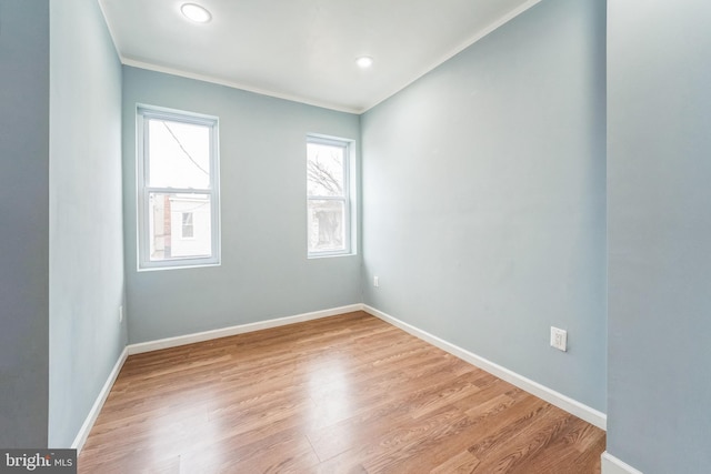 spare room featuring ornamental molding and light hardwood / wood-style floors