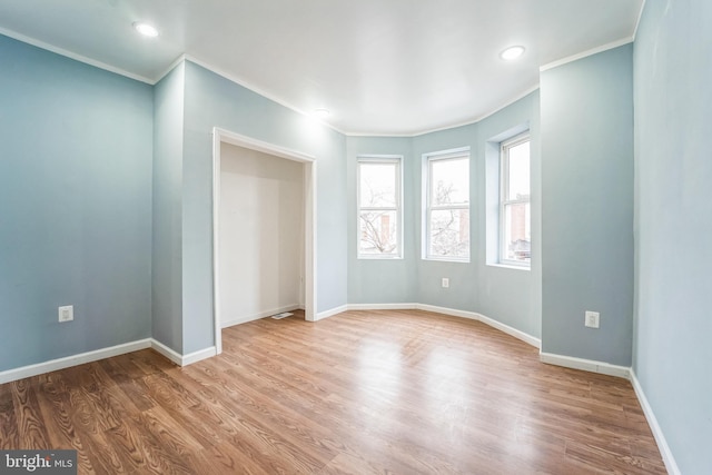 unfurnished room featuring hardwood / wood-style floors and ornamental molding